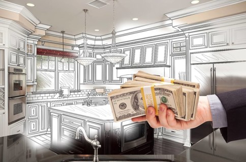 Hand holding stacks of money over custom kitchen design drawing and photo combination