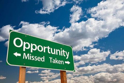 Opportunity missed and taken green road sign over dramatic blue sky and clouds