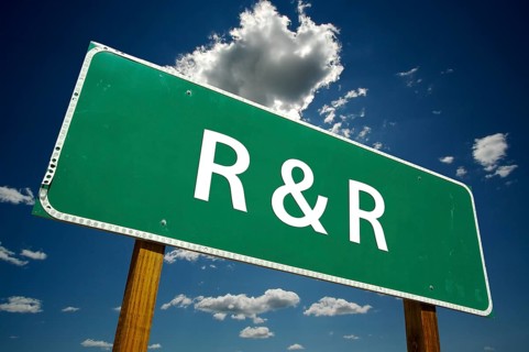 R and R road sign with dramatic clouds and sky