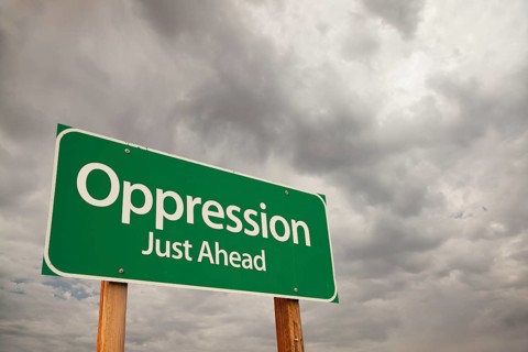 Oppression just ahead green road sign with dramatic storm clouds and sky