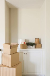 Variety of packed moving boxes and materials in empty room
