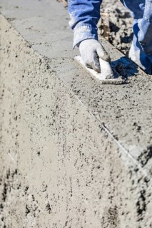 Pool construction worker working with wood float on wet concrete