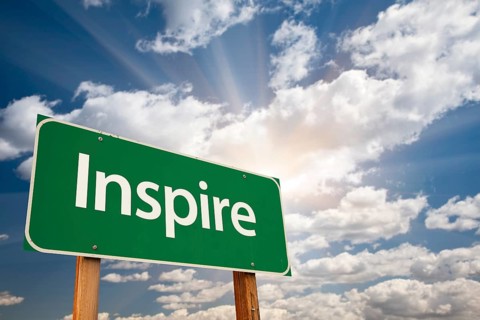 Inspire green road sign with dramatic clouds and sky