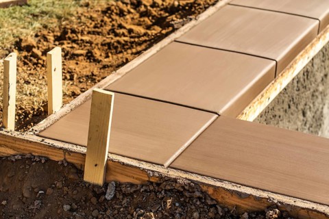 Fresh pool coping cement drying within wood framing