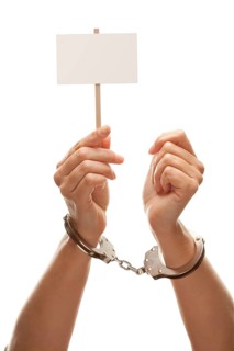 Handcuffed woman holding blank white sign isolated on a white background