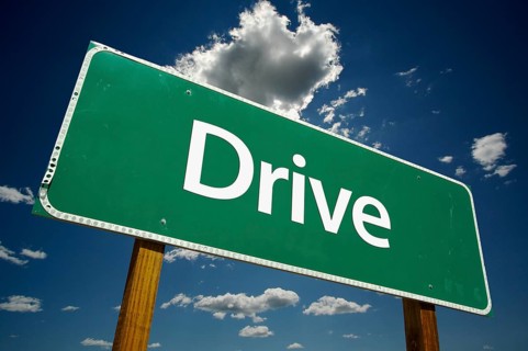 Drive green road sign with dramatic clouds and sky