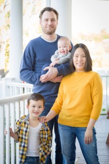 Young mixed-race chinese and caucasian family portrait on their front porch