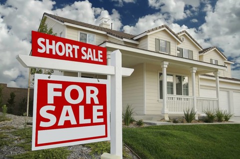 Short sale home for sale real estate sign and house