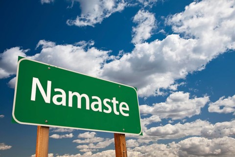Namaste green road sign with copy room over the dramatic clouds and sky