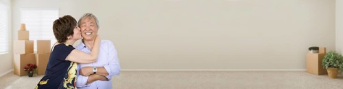 Banner of senior chinese couple inside empty room with moving boxes and plants