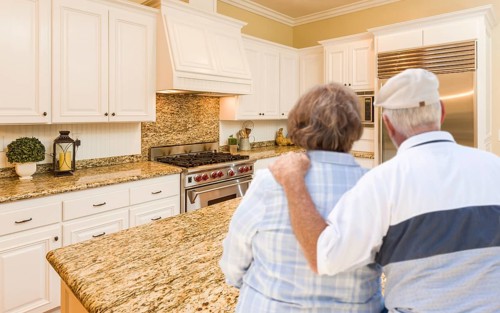 Happy senior couple looking over beautiful custom kitchen design