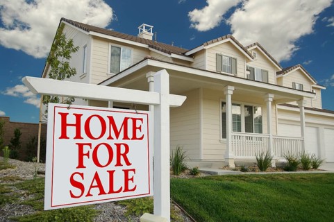 Home for sale sign in front of new house