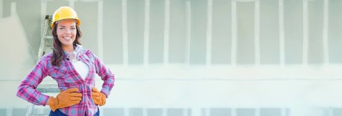 Female contractor wearing hard hat against dywall banner background with ladder