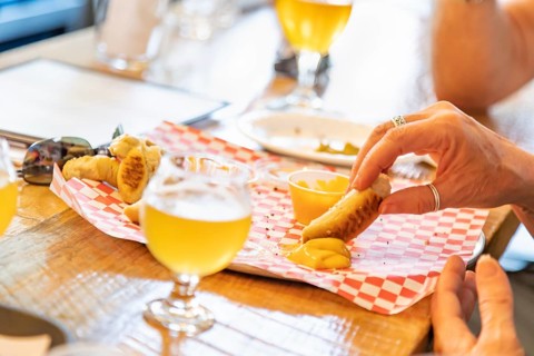 Woman enjoys warm pretzels and micro brew beer