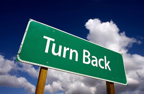Turn back road sign with dramatic clouds and sky