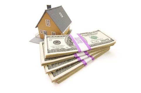 Home and stacks of money isolated on a white background