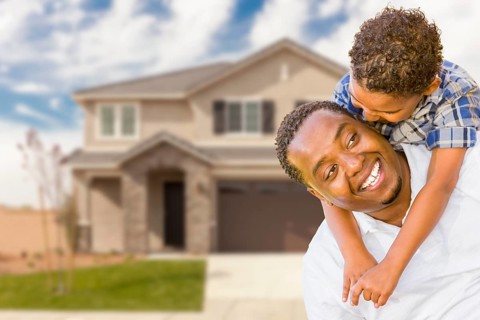 Happy playful african american father and mixed-race son in front of house