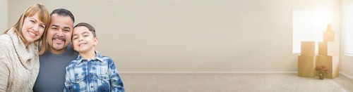 mixed-race family in empty room with moving boxes banner