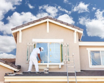 Busy house painter painting the trim and shutters of A home