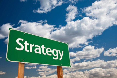 Strategy green road sign with copy room over the dramatic clouds and sky