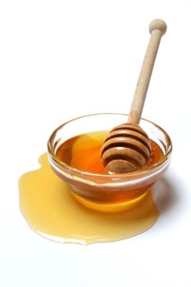 Bee honey with honey spoon in bowl