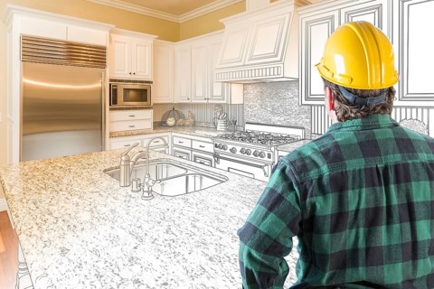 Male contractor with hard hat looking at custom kitchen drawing photo combination on white