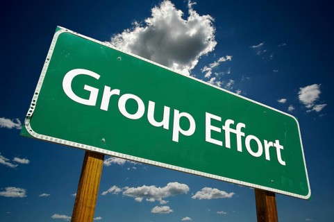 Group effort green road sign with dramatic clouds and sky