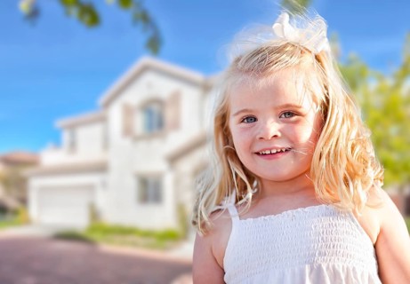 Cute smiling girl playing in front yard of house