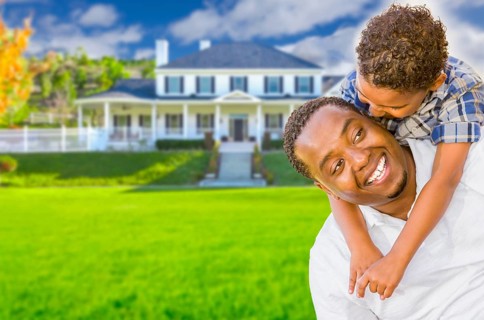 Happy playful african american father and mixed-race son in front of house