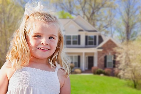 Cute smiling girl playing in front yard of house