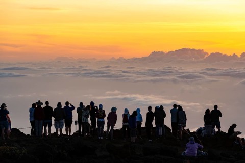 Touristen beobachten den Sonnenuntergang auf dem Gipfel des Haleakala Vulkan