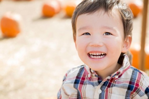 Cute mixed-race young boy having fun at the pumpkin patch