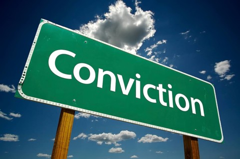 Conviction road sign with dramatic clouds and sky