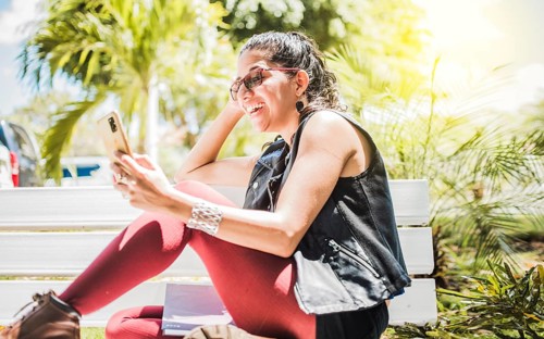 Girl sitting on a bench checking her cell phone