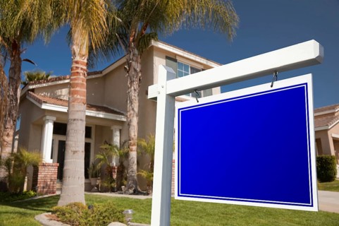 Blank real estate sign in front of house