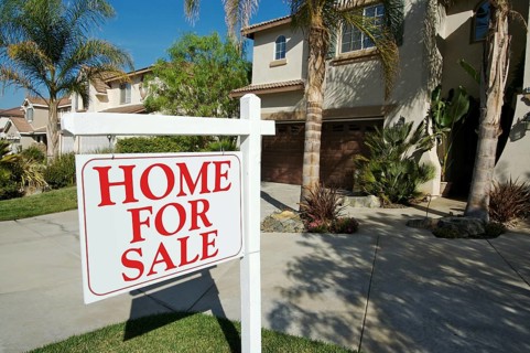 Home for sale sign in front of new house
