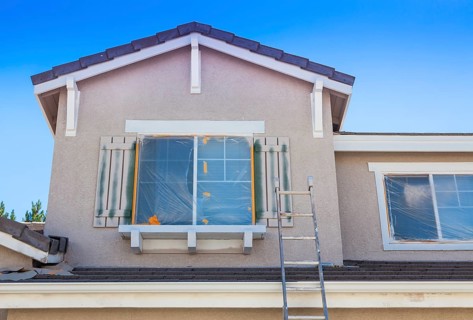 Construction ladder leaning up against A house ready for new paint