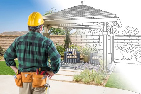 Contractor standing looking at patio pergola design drawing and photo combination