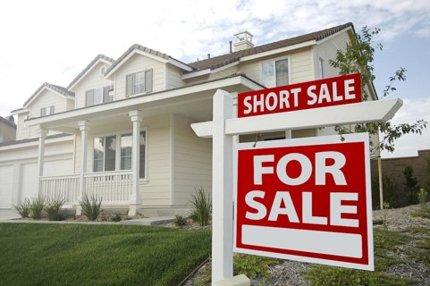 Short sale home for sale real estate sign and house