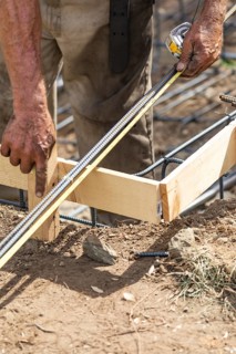 Worker measuring steel rebar at construction site