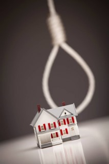 Small house with hangman's noose behind on grey background