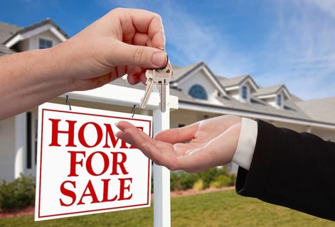 Handing over the house keys in front of a beautiful new home