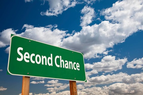 Second chance green road sign over clouds and sky