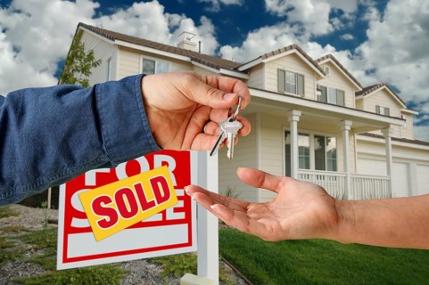Handing over the keys to A new home with sold home for sale sign