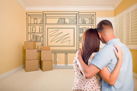 Hugging military couple in empty room with shelf design drawing on wall