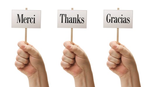 Three signs in male fists saying merci