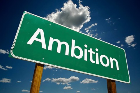 Ambition green road sign over dramatic sky and clouds