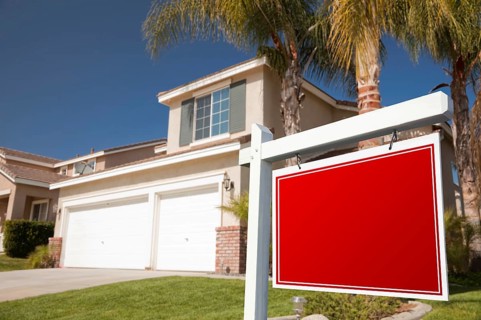 Blank real estate sign in front of house