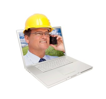 Laptop and man with hard hat on cell phone extruding the screen
