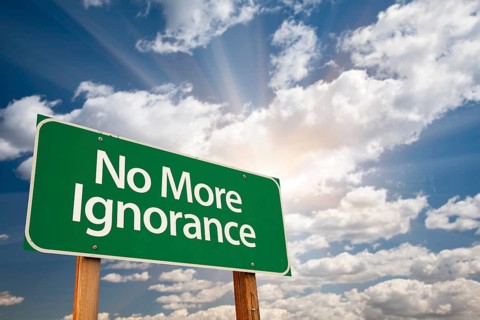 No more ignorance green road sign with dramatic clouds and sky